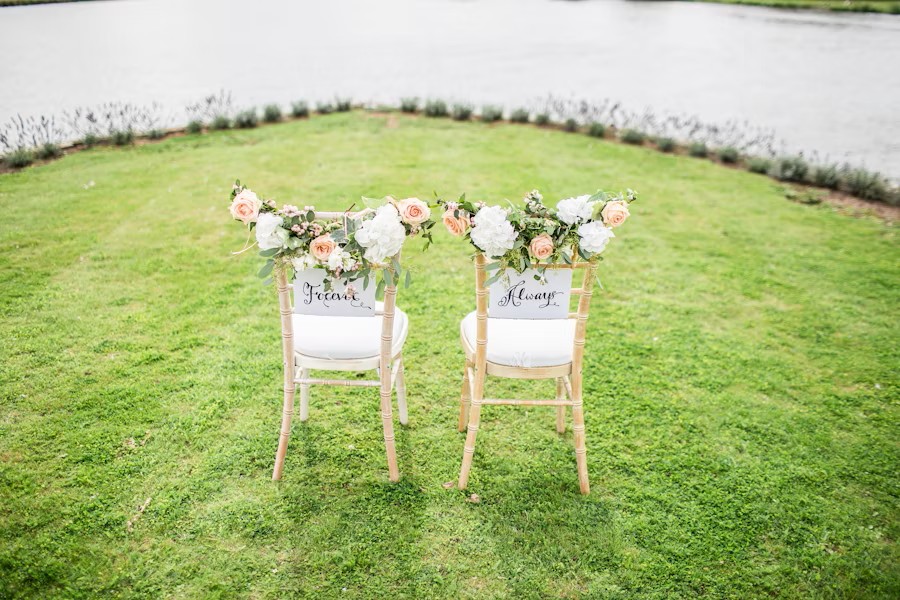 wedding seats with flowers beside a lake