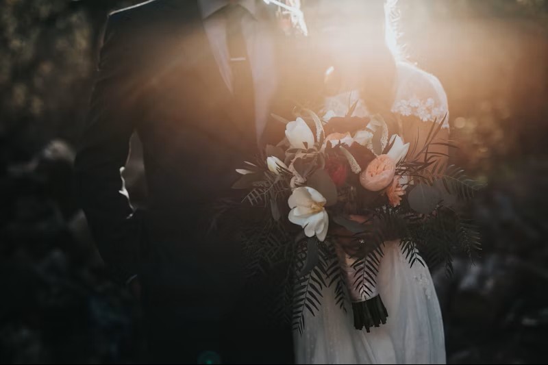 wedding couple with flowers and sun shine.