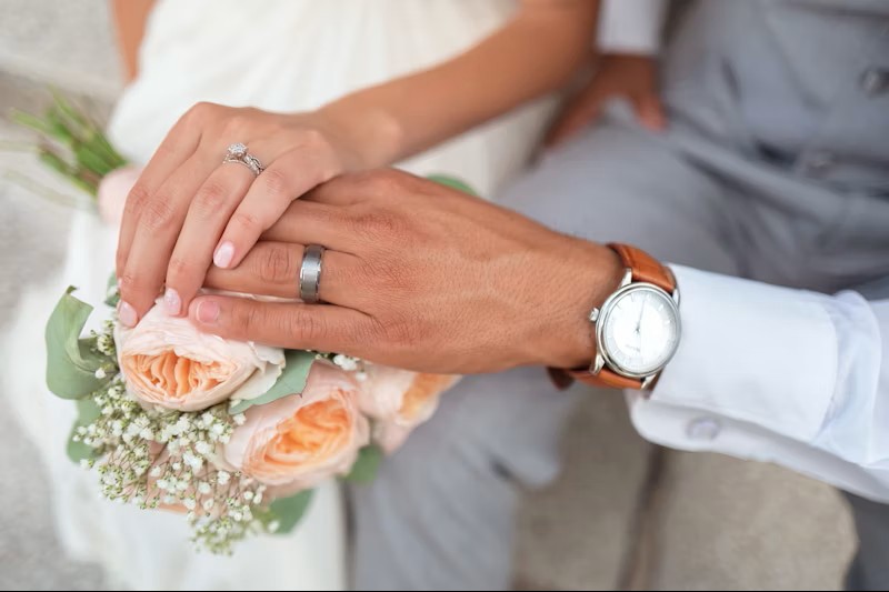 wedding hands with rings and flowers